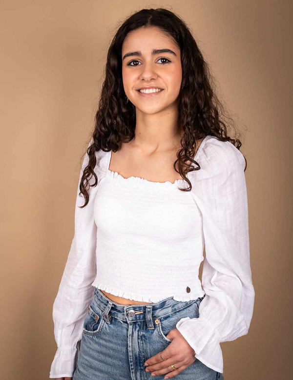 Anne is een kindermodel met bruin krullend haar en en bruine ogen