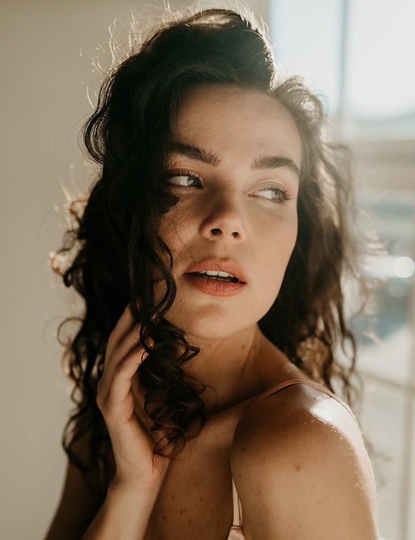 Vrouwelijk model met bruin krullend haar Anouk D.