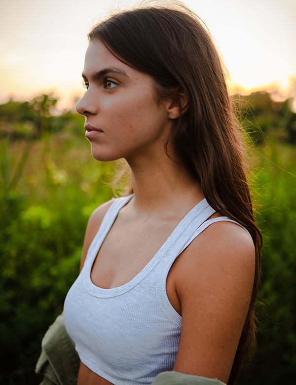 Tienermodel met groene ogen en donkerbruin haar.