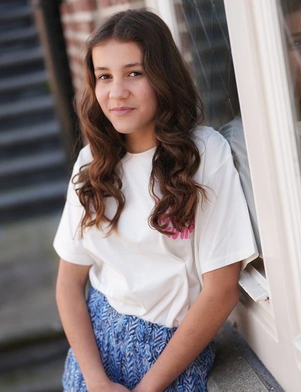 Isey is een kindermodel met bruin lang haar en bruine ogen.