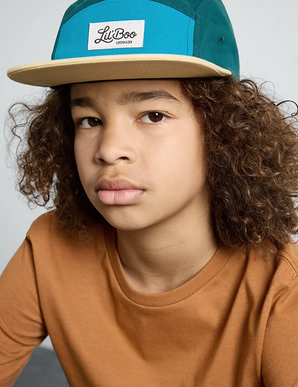 Kinderlijk model met bruin krullend haar Maxim A.