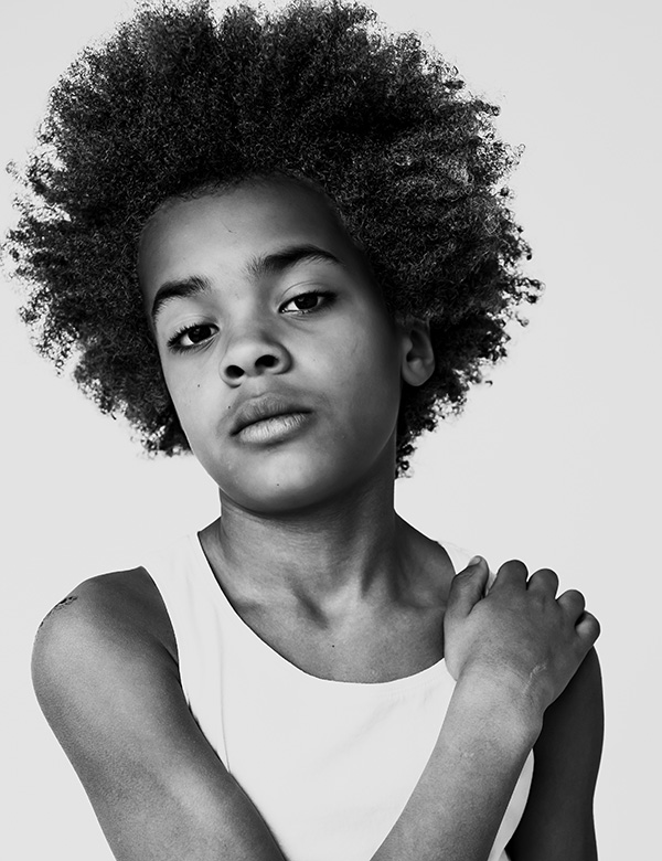 Kinderlijk model met bruin krullend haar Zayvien.