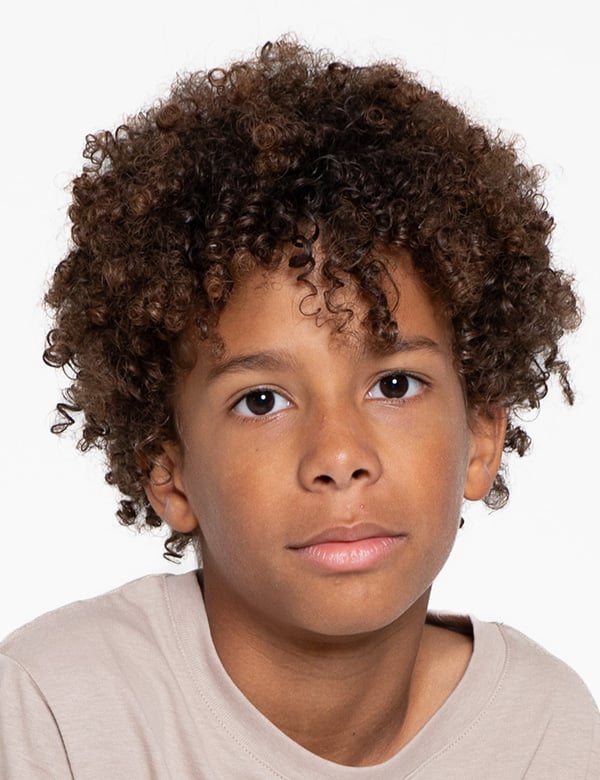 Jeremiah is een kindermodel met bruin krullend haar en bruine ogen