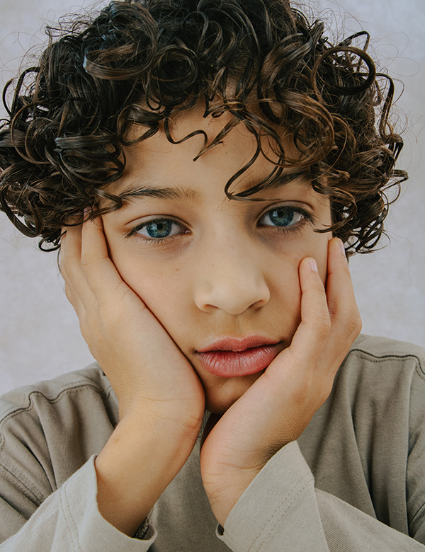 Kinderlijk model met donkerblonde krullen.