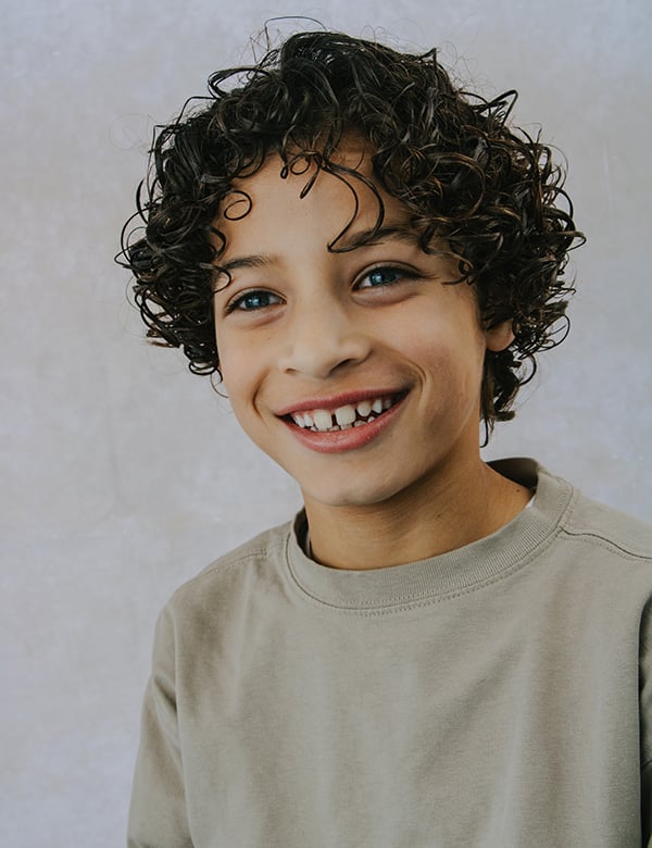 Kinderlijk model met donkerblonde krullen.