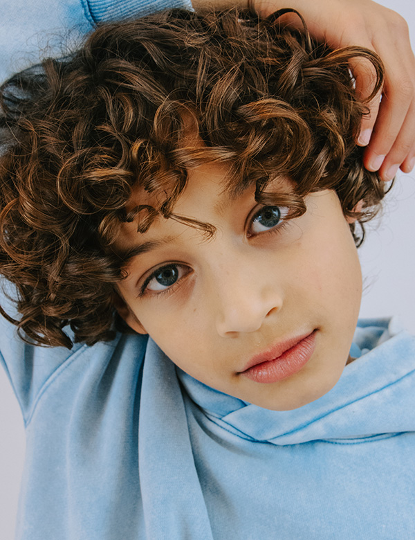 Kinderlijk model met donkerblonde krullen.