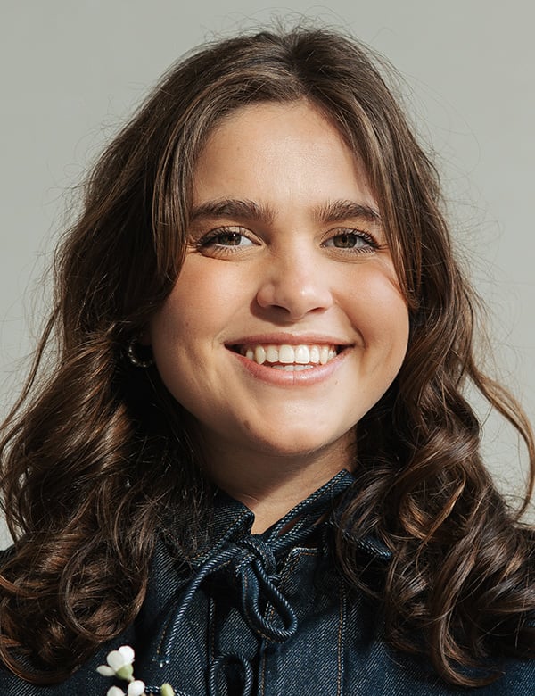 Vrouwelijk model met bruin haar roos bo.