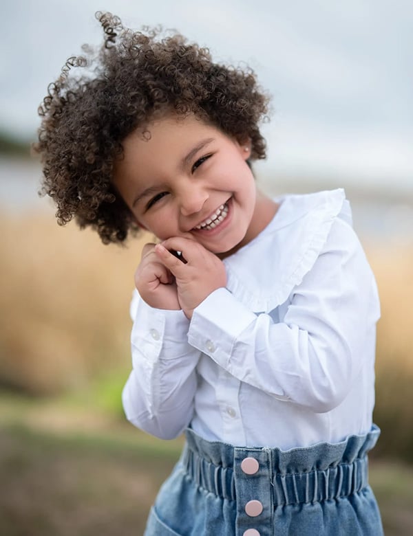 Kinderlijk model met donkerbruin kroes haar en bruine ogen Nadine Noor.