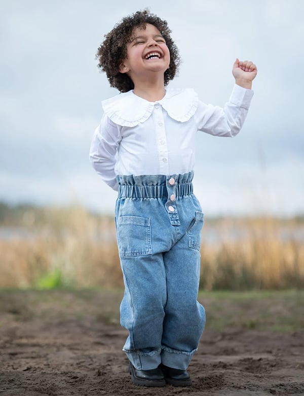 Kinderlijk model met donkerbruin kroes haar en bruine ogen Nadine Noor.