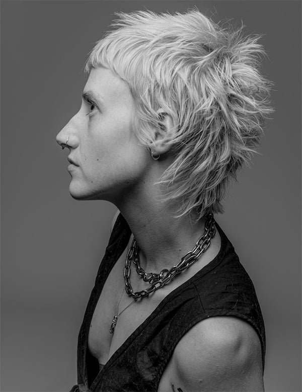 Non-binair model met lichtblond haar Fede